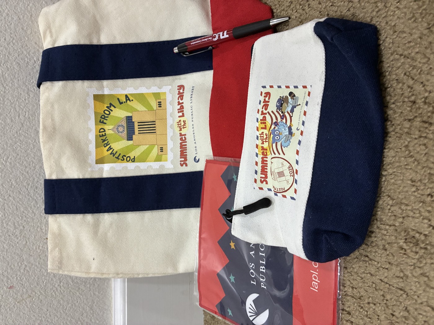 A Los Angeles Public Library tote bag, pouch, pen, and sticker given to Ashton as a thank-you gift